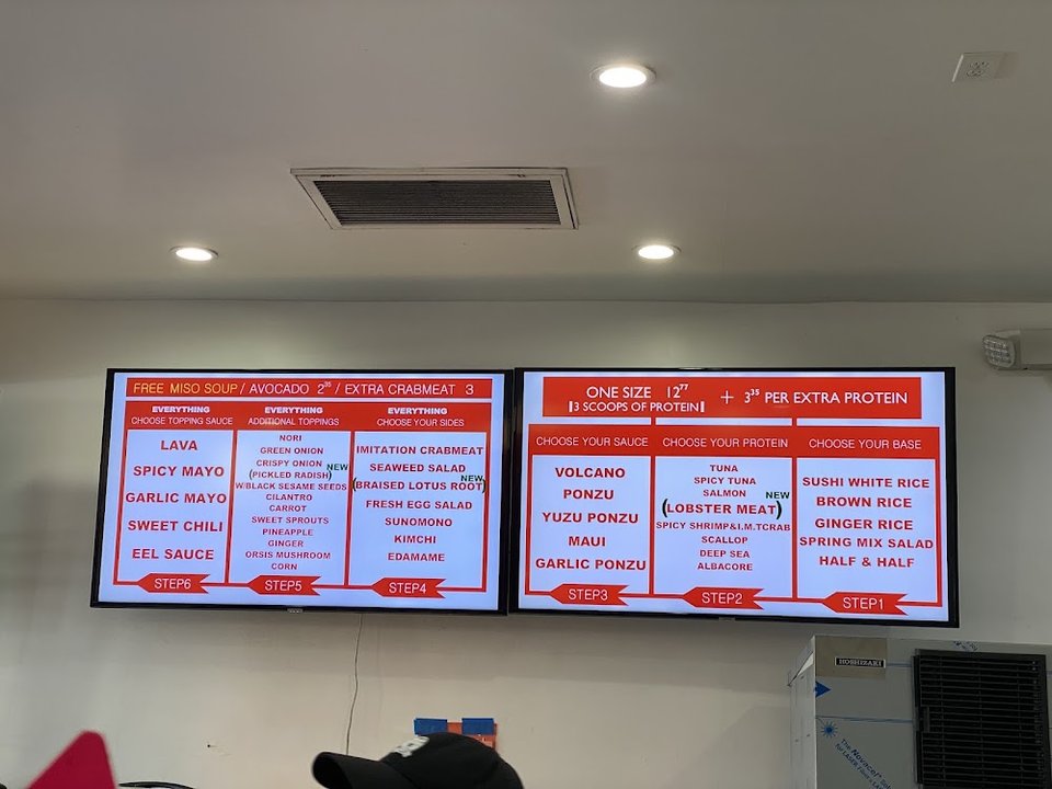 Menu board showing poke, drinks, and extras